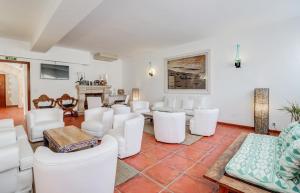 sala de estar con sillas blancas y mesa en Hoposa Niu en Cala de Sant Vicent