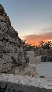 a stone wall with steps in front of a sunset at b&b Olio su Pietra in Castellana Grotte
