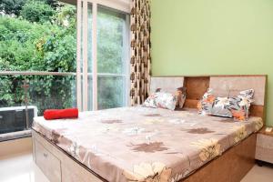 a large bed in a room with a large window at Ranghavi sands Apartment with Pool - near beach and Dabolim Airport in Bogmolo