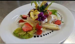 un plato blanco de comida con frutas y hortalizas en Panoramahotel Steirerland, en Kitzeck im Sausal