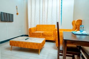 uma sala de estar com um sofá e uma mesa em MLIMWA HILL PALACE em Dodoma