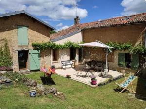 a garden with a patio and a house at Jolie chambre d'hôtes in Iteuil