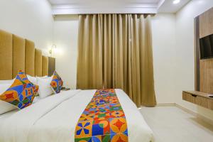 a bedroom with a large bed and a television at FabHotel Vishesh Villas in New Delhi
