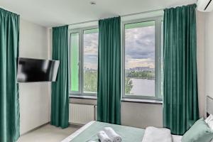 Schlafzimmer mit grünen Vorhängen, einem Bett und einem Fenster in der Unterkunft Green Line Hotel in Kiew
