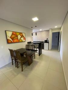 a dining room and kitchen with a table and chairs at Residencial Dona Clara in Pontal do Paraná