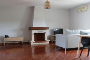 een woonkamer met een bank en een open haard bij Casas do Monte in Palmela