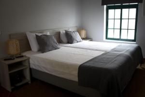 1 dormitorio con 1 cama grande y ventana en Casas do Monte, en Palmela