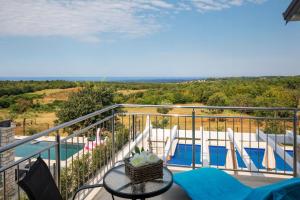 a balcony with a table and chairs and a pool at Beautiful Villa Fior di Lavanda in Visnjan in Štuti