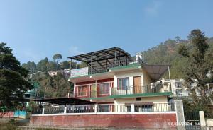 a building with a balcony on top of it at Four Season Homestay Bhowali Bhimtal in Bhowāli