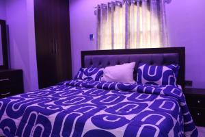 a purple bedroom with a large bed with a purple room at Flat 1, ECOWAS ESTATE in Abuja