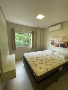sypialnia z dużym łóżkiem i oknem w obiekcie Residencial Dona Clara w mieście Pontal do Paraná