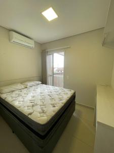 Bett in einem Zimmer mit Fenster in der Unterkunft Residencial Dona Clara in Pontal do Paraná