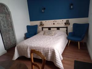 1 dormitorio con 1 cama y 2 sillas azules en Lorali, en Gohier