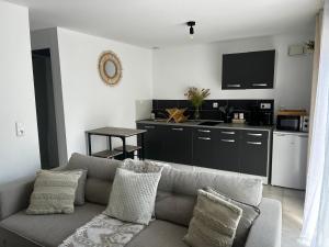 a living room with a couch and a kitchen at Maisonnette 32m2 climatisé avec jacuzzi au calme. in Trans-en-Provence