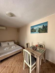 Apartman Nina في ريسان: غرفة نوم بسرير وطاولة مع كراسي