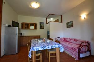 a small kitchen with a table and a refrigerator at Raffaella in Bibione