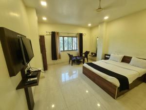a bedroom with a bed and a flat screen tv at The Living Space in Lonavala