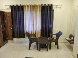 a table and chairs in a room with curtains at The Living Space in Lonavala