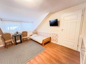 オルシュティネクにあるWiatraki Nature Resortのベッドルーム1室(ベッド1台、壁掛けテレビ付)