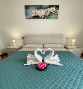 zwei Schwäne machen ein Herz auf einem Bett in der Unterkunft Water Lily Apartment in Bardello