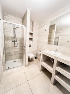 a bathroom with a shower and a sink and a toilet at Wiatraki Nature Resort in Olsztynek