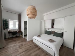 Le Laurencin Sens - Le Parisien في سونس: غرفة نوم بيضاء مع سرير ومكتب