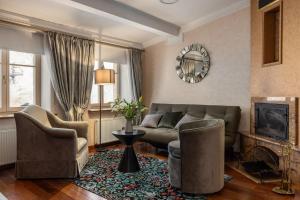 ein Wohnzimmer mit Sofa, Sesseln und Kamin in der Unterkunft M5 self-service Boutique Hotel in Riga