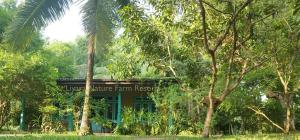 een gebouw midden in een bos van bomen bij Liyara Nature Farm Resort in Gampaha
