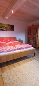 a bedroom with a large bed with red pillows at Scherntreinerhof in Westendorf