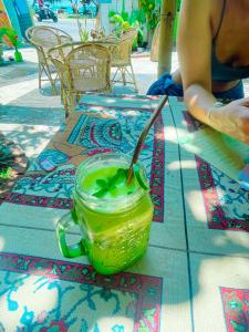 阿漢伽馬的住宿－Gaia Ocean Surf Yoga，桌子上玻璃瓶里的一杯绿饮料