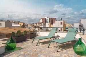 zwei grüne Stühle und ein Tisch auf einem Dach in der Unterkunft Dimore Calculli - Puglia Mia Apartments in Monopoli
