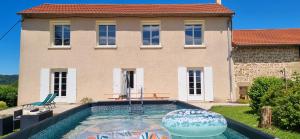 a house with a swimming pool in front of a house at La maison d’Emilie in Margès