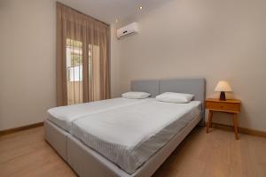 a white bedroom with a bed and a window at Lihi's Sea View in Rhodes Town