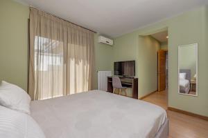 a bedroom with a bed and a desk and a television at Lihi's Sea View in Rhodes Town