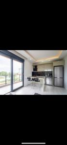 a large kitchen with a table and a large window at Antalya Havalimanına Yakın Havuzlu 1+1 Lux Daire in Antalya