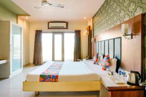 A bed or beds in a room at FabHotel Prime Devanshi Inn