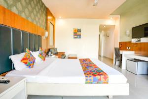 1 dormitorio con 1 cama blanca grande y cocina en FabHotel Prime Devanshi Inn en Kalamboli