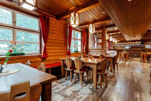 un restaurant avec des murs en bois, des tables et des chaises dans l'établissement Hotel Mikulášska Chata, à Demänovská Dolina