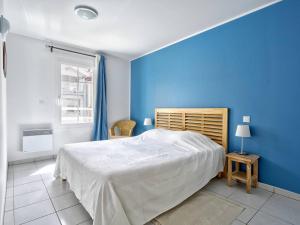 ein blaues Schlafzimmer mit einem Bett und einer blauen Wand in der Unterkunft T3 Confortable à Arcachon Centre avec Loggia, Parking et Clim, à 400m de la Plage! - FR-1-433-120 in Arcachon