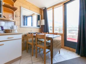 a kitchen with a wooden table and chairs and windows at Duplex 3 pièces 7 pers, Balcon Sud, Wi-Fi, proche pistes - FR-1-314-283 in Morzine