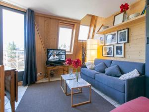 a living room with a blue couch and a tv at Duplex 3 pièces 7 pers, Balcon Sud, Wi-Fi, proche pistes - FR-1-314-283 in Morzine