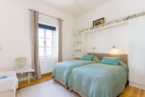 a bedroom with two beds and a window at Casa Cima Rio in Alcácer do Sal