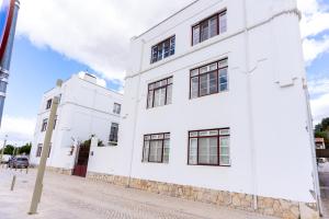 a white building on the side of a street at Casa Cima Rio in Alcácer do Sal
