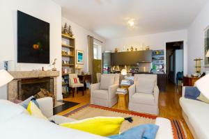 a living room with white furniture and a fireplace at Casa Cima Rio in Alcácer do Sal