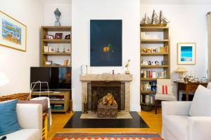 a living room with a fireplace and a tv at Casa Cima Rio in Alcácer do Sal