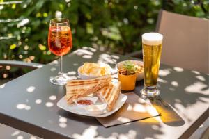 stolik z talerzem jedzenia i dwie szklanki piwa w obiekcie Hotel Al Castello w mieście Torri del Benaco