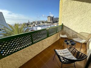 a balcony with two chairs and a table on it at Las Dunas DM sea view in San Bartolomé