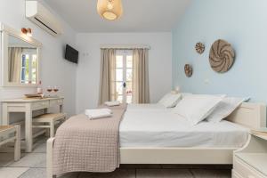 ein weißes Schlafzimmer mit einem großen Bett und einem Schreibtisch in der Unterkunft Hotel Francesca in Agios Prokopios