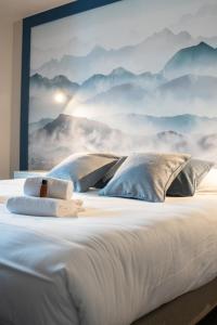 a bedroom with a mountain mural on the wall at Hotel Le Bois Joli in Bernex