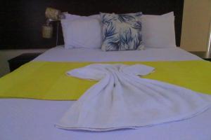 un accappatoio bianco appoggiato sopra un letto di The upperroom bed and breakfast a Francistown